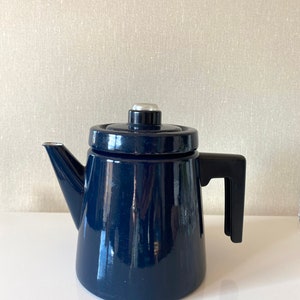 May include: A dark blue enamel coffee pot with a black handle and a silver knob on the lid.