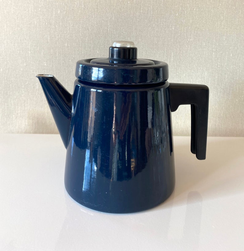 May include: A dark blue enamel coffee pot with a black handle and a silver lid.