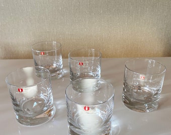 May include: Set of six clear glass tumblers with a textured design. Each tumbler has a small red sticker with the letter "i" on it.
