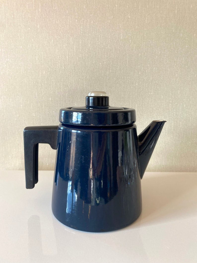 May include: A dark blue enamel coffee pot with a black handle and a silver lid.