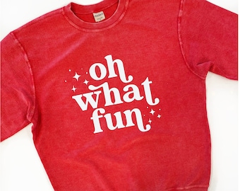 Puede incluir: Sudadera roja de punto de gofre con texto blanco que dice "oh what fun" con pequeñas estrellas blancas a cada lado del texto.