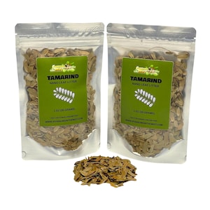 May include: Two clear plastic bags filled with brown tamarind nano leaf litter, each with a green label. The labels read "TAMARIND NANO LEAF LITTER" and "1 OZ (30 GRAMS)". A small pile of the leaf litter sits between the bags.