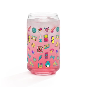 Könnte beinhalten: Eine rosa Glasdose mit einem 90er-Jahre-Design. Die Dose ist mit einer rosa Flüssigkeit und Eis gefüllt. Das Design zeigt eine Vielzahl von 90er-Jahre-Symbolen, darunter ein Kassettenband, ein Ghettoblaster, eine Spielkassette, ein Rollschuh, ein Blitz, ein Telefon, ein Schnuller, ein Herz und Würfel.