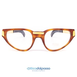 May include: Brown tortoiseshell eyeglasses with gold accents and clear lenses. The brand name "Moda Italia" is printed on the right lens.