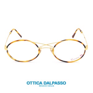 May include: Tortoise shell eyeglasses with gold metal accents and clear lenses. The brand name "Carrera" is visible on the right lens.