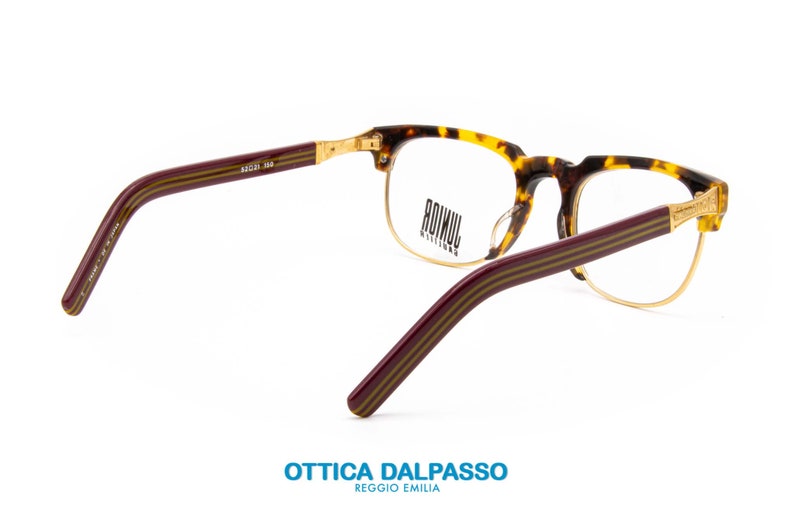May include: Tortoise shell eyeglasses with gold metal accents and burgundy striped arms. The brand name "ROIMUI" is printed on the lenses.