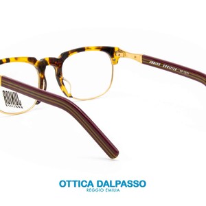 May include: Tortoise shell and gold-rimmed eyeglasses with burgundy temples featuring a striped pattern. The arms are labeled "JUNIOR KRIZIA" and "JF-1221".