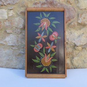 May include: A rectangular wooden serving tray with a dark brown finish, featuring a hand-painted floral design in shades of red, blue, yellow, and green. The tray has natural wood-toned edges and handles at the top and bottom ends.