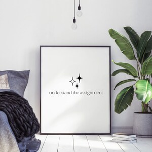 K&ouml;nnte beinhalten: Schwarz-wei&szlig;es, druckbares Wandbild mit minimalistischem Design, das drei Sterne und den Text "understand the assignment" zeigt.