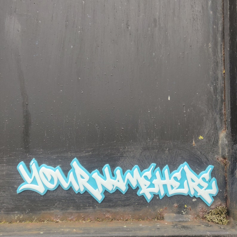 a 3d printed graffiti tag that says 'your name here' in white with a blue background