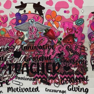 Pu&ograve; includere: Grafica rosa e bianca con stampa di mucca, fiori, cuori e fragole. L'immagine include le parole "TEACHER", "Inspire", "Motivated" e altre parole positive. Il design ha un effetto glitterato.