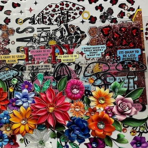 Pu&ograve; includere: Un collage colorato di adesivi floreali ed elementi decorativi. Il design include vari fiori nei toni del rosso, arancione, blu e rosa, con sovrapposizioni di testo come "It's okay to be yourself" e "My Mental Break".