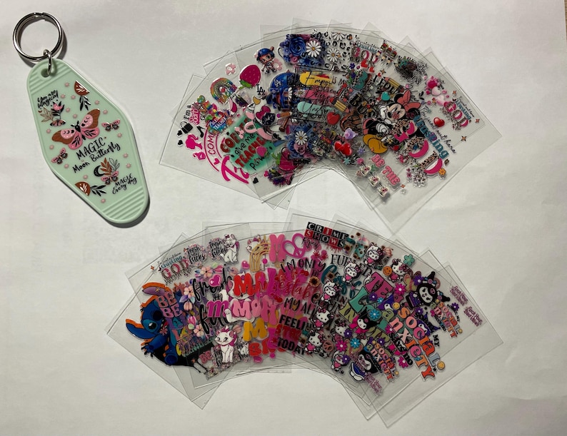 May include: A set of clear plastic sheets with colorful stickers featuring various designs and phrases, including "Magic Moon Butterfly", "Be Kind", "Feelin' Good", "Social Anxiety", and "Mom My All Time Favorite".