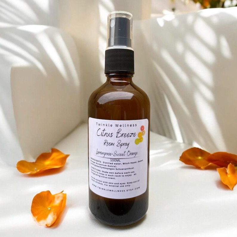 May include: A brown glass bottle with a black spray nozzle and a white label that reads "Twinkle Wellness Citrus Breeze Room Spray Lemongrass-Sweet Orange 100ML Ingredients: Distilled water, Witch Hazel, Lemon essential oil, Sweet Orange essential oil, Lemongrass essential oil,  Alcohol (Isopropyl Alcohol),  Fragrance (Pogogen Schoenanthol),  Preservatives. Shake well before each use.  Directions:  Spray each room to enjoy an uplifting citrus scent. For external use only. Keep out of contact with skin and eyes. www.twinklewellness.etsy.com"