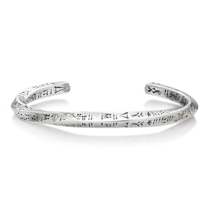 May include: A silver bangle bracelet with a twisted design and engraved markings.