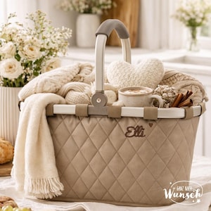 Pu&ograve; includere: Un cesto trapuntato beige con telaio in metallo argentato e manico grigio. Il cesto presenta il nome ricamato Elli con un piccolo cuore. All'interno ci sono coperte lavorate a maglia color crema, un cuscino a forma di cuore, una tazza e cannella.