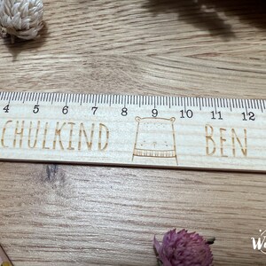 May include: A wooden ruler with a bear illustration and the words "SCHULKIND BEN" engraved on it. The ruler has markings from 3 to 14.