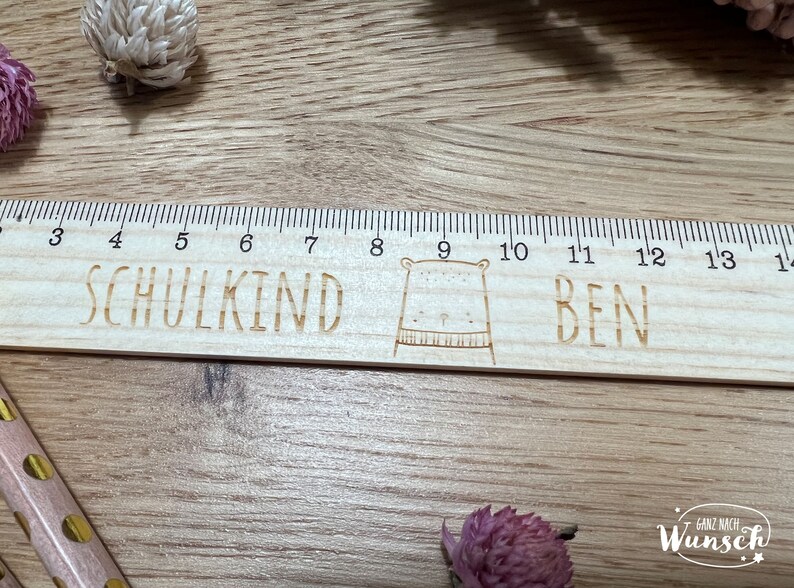 May include: A wooden ruler with a bear illustration and the words "SCHULKIND BEN" engraved on it. The ruler has markings from 3 to 14.