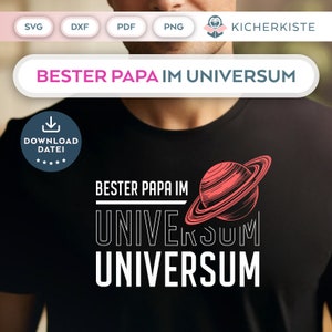 Op de afbeelding: Zwart T-shirt met witte tekst die "Bester Papa im Universum" zegt en een rood-witte illustratie van een planeet met ringen.