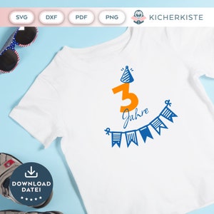 May include: A white t-shirt with a blue and orange design that says "3 Jahre" with a party hat on top of the number 3. The design also includes a string of blue and white flags.