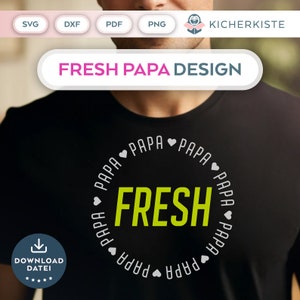 Op de afbeelding: Een zwart T-shirt met een wit cirkelontwerp. De cirkel bevat het woord "FRESH" in groene letters en het woord "PAPA" wordt herhaald rond de cirkel met een hart tussen elk woord.