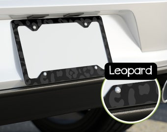May include: Black and white leopard print license plate frame with the word "Leopard" printed in white on the frame.