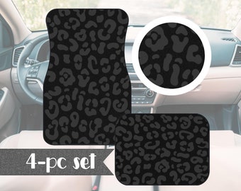 May include: A 4-piece set of black car floor mats with a leopard print design. The mats are shown in a car interior.