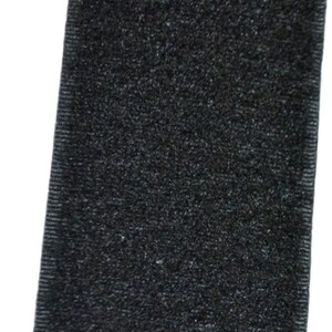 Op de afbeelding: Zwarte klittenband, ook wel bekend als Velcro, met een zachte, pluche textuur.