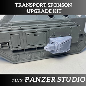 May include: A gray plastic model kit for a transport vehicle with a turret and a gun barrel. The kit is labeled "TRANSPORT SPONSON UPGRADE KIT" and "TINY PANZER STUDIO".