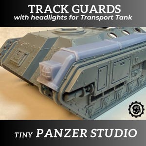 May include: Gray plastic track guards with headlights for a transport tank model. The guards are designed to fit over the tracks of the tank and add a realistic touch to the model. The guards are made of high-quality plastic and are easy to assemble.  "TRACK GUARDS with headlights for Transport Tank" and "TINY PANZER STUDIO" are printed on the image.