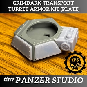 May include: A gray Grimdark Transport Turret Armor Kit (Plate) with a hexagonal base and a detailed turret section. The kit features riveted panels and is labeled "tiny PANZER STUDIO."
