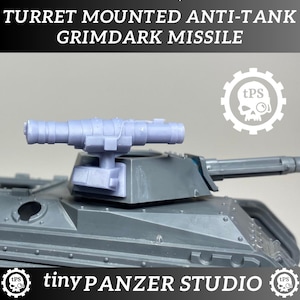 Puede incluir: Un modelo de tanque gris con un misil antitanque montado en la torreta. El texto "TURRET MOUNTED ANTI-TANK GRIMDARK MISSILE" está en la parte superior. El texto "tinyPANZER STUDIO" está en la parte inferior, con un logotipo de calavera a cada lado.