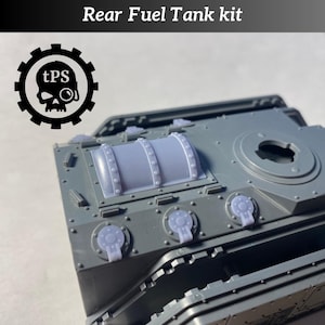 Puede incluir: Kit de depósito de combustible trasero de plástico gris con el texto "Rear Fuel Tank kit" en la parte superior. El kit incluye un depósito cilíndrico y tres componentes circulares. Un logotipo en blanco y negro con una calavera está a la izquierda.