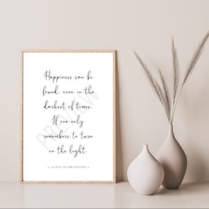 Può includere: Una citazione stampabile di Albus Silente, un personaggio immaginario della serie di Harry Potter, che recita: "La felicità si può trovare, anche nei momenti più bui. Se uno ricorda solo di accendere la luce." La citazione è stampata in corsivo nero su sfondo bianco.