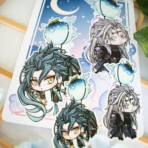 Könnte beinhalten: Ein Bogen mit Aufklebern mit Anime-Charakteren mit langen Haaren und detaillierten Outfits. Der Hintergrund ist ein blauer Farbverlauf mit einem Halbmond und Sternen. Die Aufkleber zeigen Charaktere mit blauen und silbernen Haaren sowie Kugelfische.