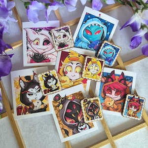 Könnte beinhalten: Eine Sammlung von vier rechteckigen Kunstdrucken und vier passenden Anstecknadeln mit gewelltem Rand, die Zeichentrickfiguren in tierischen Kapuzenpullovern zeigen, darunter eine weiße Spinne, ein blauer Hai, eine gelbe Ente und ein roter Hirsch.
