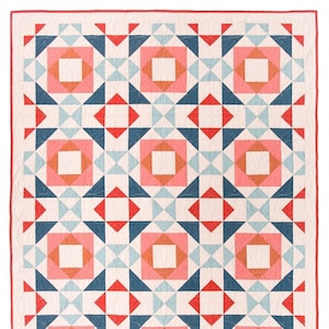 May include: A quilt with a geometric pattern in shades of pink, blue, and white. The quilt is made up of squares and triangles, and the pattern is repeated throughout the quilt.