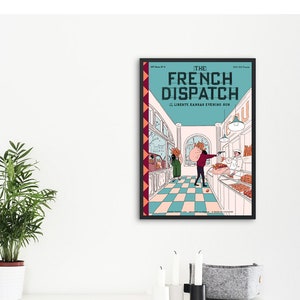 May include: Framed poster of "The French Dispatch" movie. The poster features a teal background with the title in white and a scene from the film. The scene depicts a shop interior with characters and text. The frame is black.