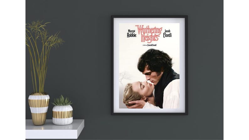 Puede incluir: P&oacute;ster enmarcado de la pel&iacute;cula "Cumbres Borrascosas" con Margot Robbie y Jacob Elordi. El p&oacute;ster muestra un primer plano de los actores en un abrazo rom&aacute;ntico. El p&oacute;ster est&aacute; en un marco negro y cuelga de una pared gris oscura.