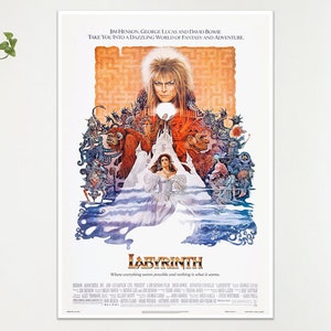 May include: A framed movie poster for the film "Labyrinth" featuring David Bowie. The poster has a central image of Bowie with a woman in a white dress. The title "Labyrinth" is at the bottom, with the names of the director and writers at the top.