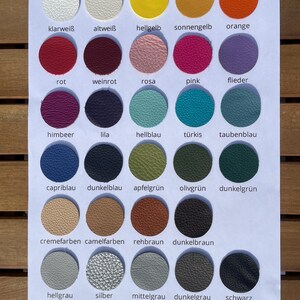 May include: A color chart featuring thirty circular leather swatches arranged in six rows and five columns. Each swatch displays a unique color, including white, yellow, orange, red, pink, purple, blue, green, brown, gray, and black, with text labels.