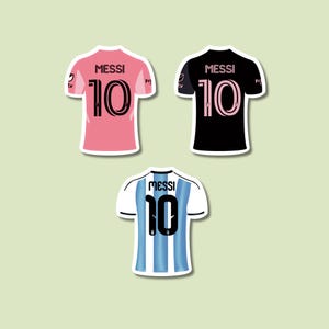 May include: Three sticker designs of soccer jerseys. One is pink with black accents, one is black with pink accents, and the last is white and light blue striped. Each jersey has the name "MESSI" and the number "10".