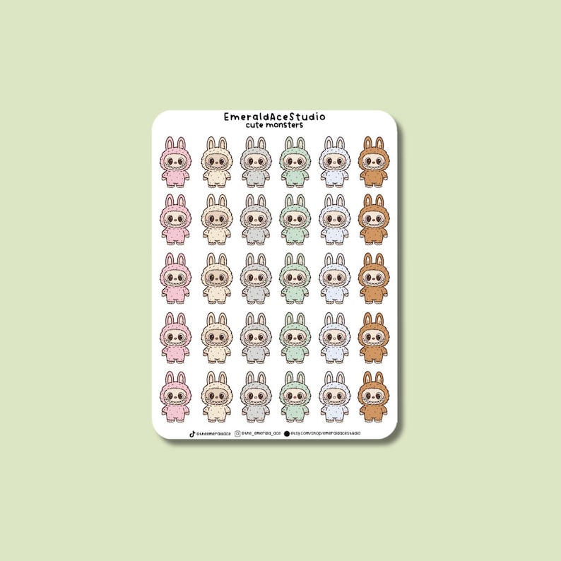 May include: A sticker sheet featuring multiple cartoon monster characters in various colors, including pink, gray, green, and brown. The stickers have a bunny-like appearance with large eyes and are wearing matching outfits. The text "EmeraldAceStudio cute monsters" is at the top.
