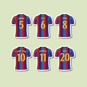 May include: Six soccer jerseys featuring vertical red and blue stripes with yellow numbers and names on the back. The jerseys display the names Cubarsí 5, Gavi 6, Pedri 8, Lamine Yamal 10, Raphinha 11, and Olmo 20 in a bold yellow font style.
