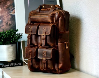 Peut inclure: Un sac à dos en cuir marron avec plusieurs poches et boucles. Le sac à dos a un aspect vieilli et est fait de cuir de haute qualité.