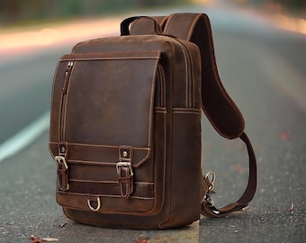 May include: A brown leather backpack with adjustable straps and multiple pockets. The backpack has a distressed look and features metal buckles.