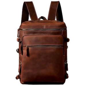 Puede incluir: Una mochila de cuero marrón con múltiples bolsillos y cremalleras. La mochila tiene correas ajustables y un asa superior.