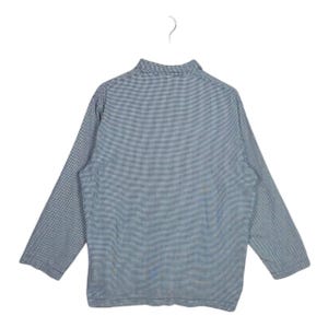 May include: A long-sleeved shirt with a blue and white checkered pattern, hanging on a white hanger. The shirt has a collared neckline and a relaxed fit. The fabric appears to be lightweight.