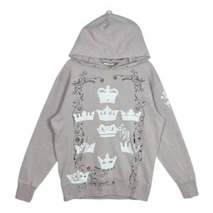 May include: A white ceramic mug with a black handle and the text "But First, Coffee" in a bold, black font. The mug is set against a blurred background, highlighting its clean design.