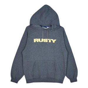 Puede incluir: Una sudadera con capucha de manga larga en color gris oscuro jaspeado, con un bolsillo tipo canguro frontal y la palabra RUSTY impresa en color amarillo claro en el pecho. La sudadera incluye un cordón ajustable a juego en el cuello.